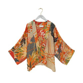 Colorful kimono-style jacket on a hanger against a white background