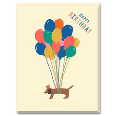 sausage dog is levitated by colourful balloons. 'happy birthday' written on the top corner. base baby pink