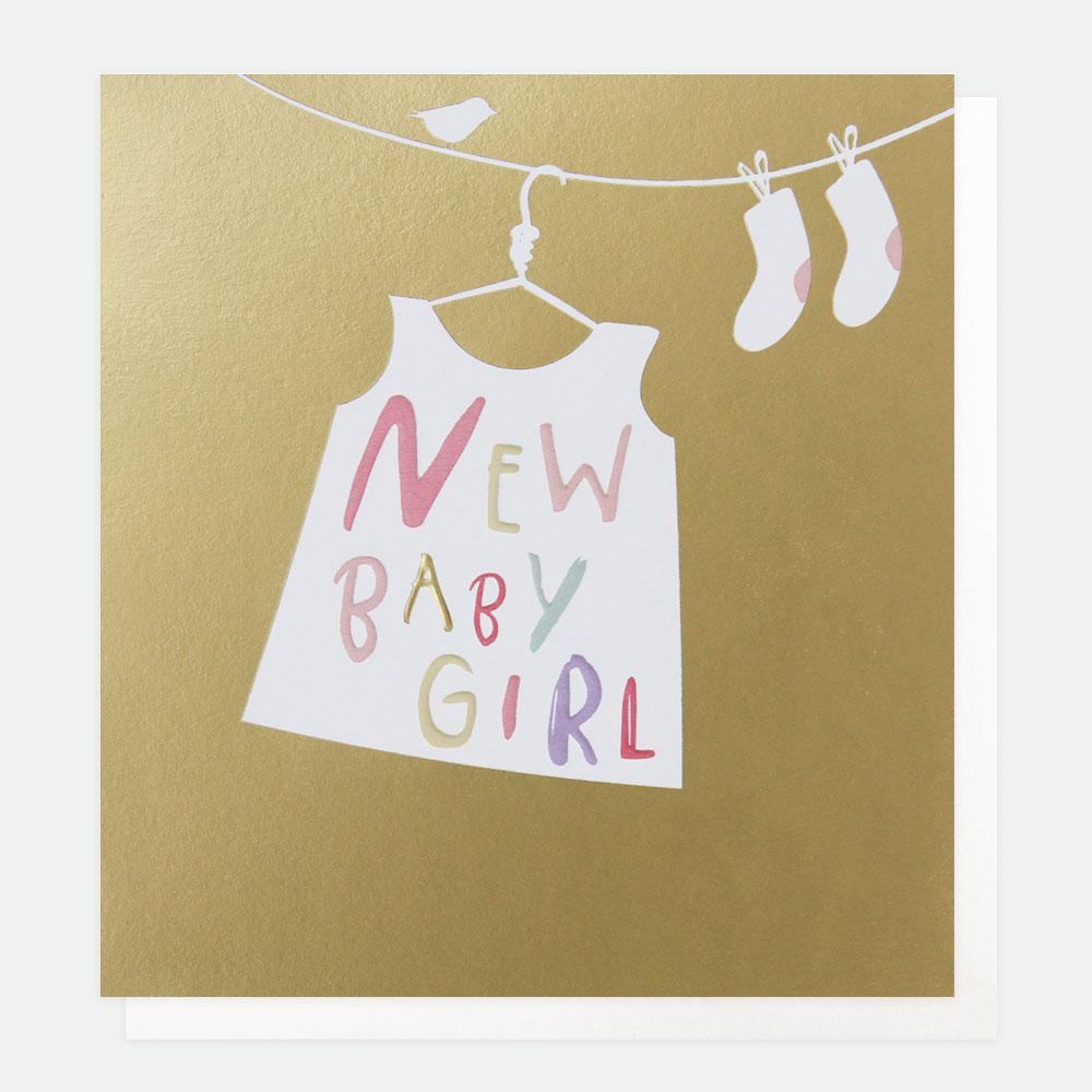 new baby girl' written on the skirt hanged on laundry holder. base gold